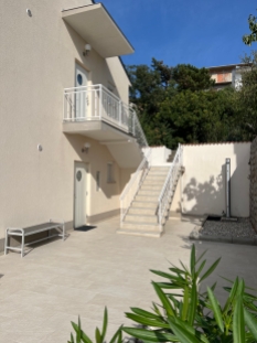 Entrance to the lower apartment, outdoor shower and the stairs to the upper apartment
